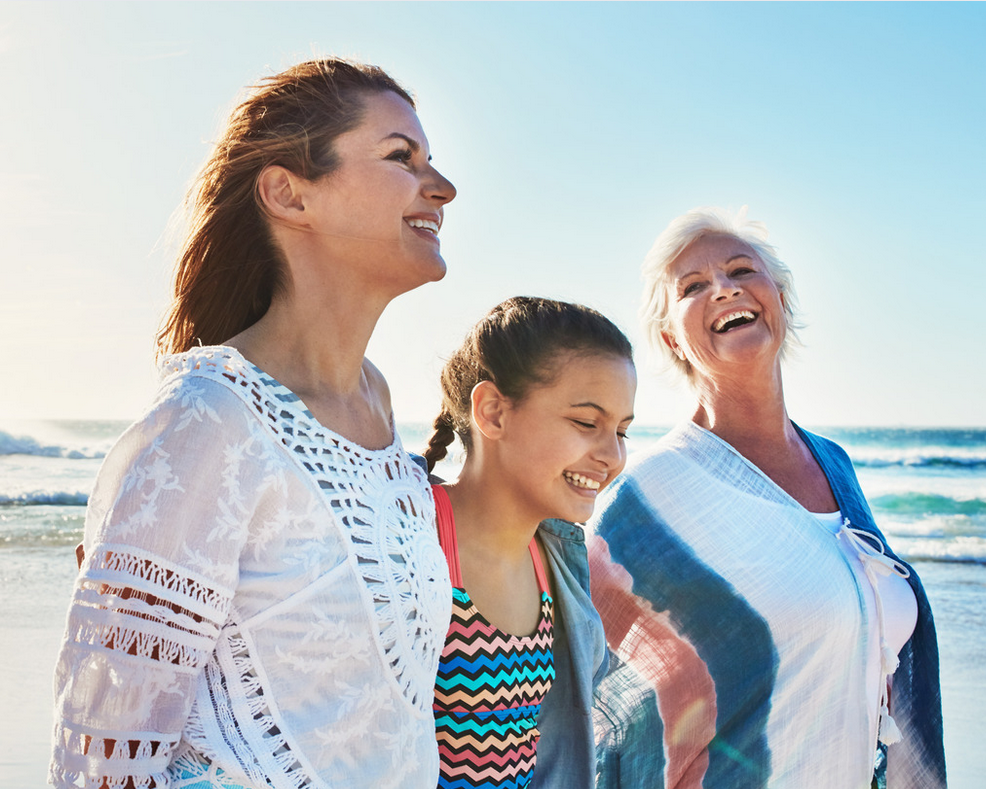 A mother, daughter, and granddaughter walking and laughing