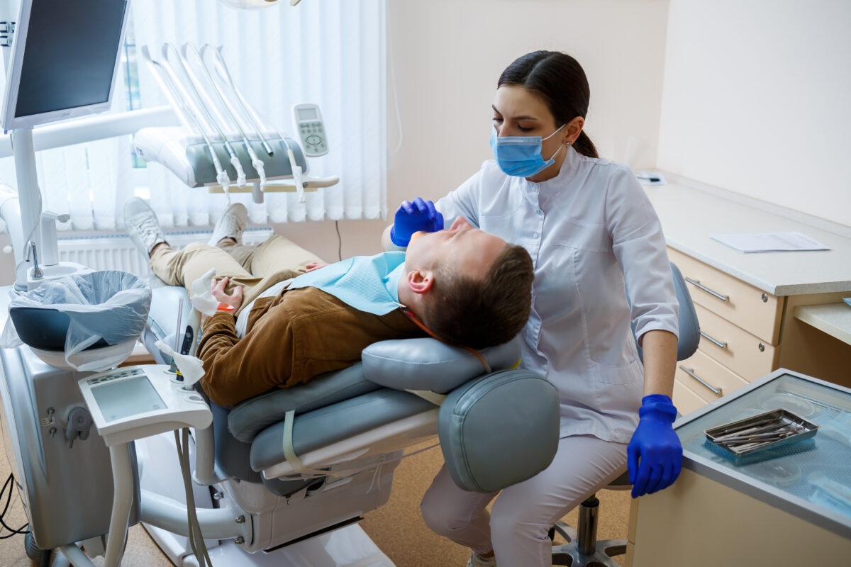 Doctor woman dentist treats the patient's teeth, proper dental care. Dental care and hygiene concept. Selective focus.