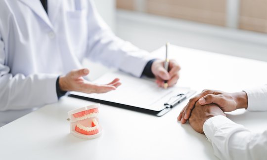 Dentist consulting with a patient about dental implant treatment options